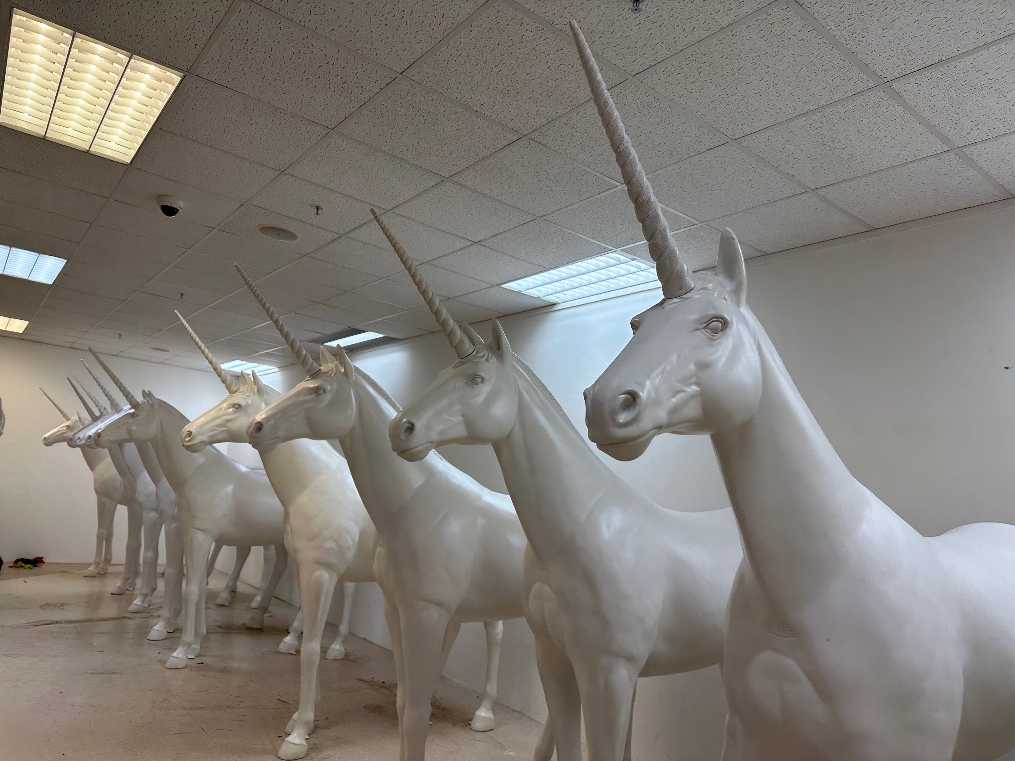 a group of eight white unicorn statues 